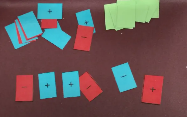 Game cards in three different colors with the symbols + and -