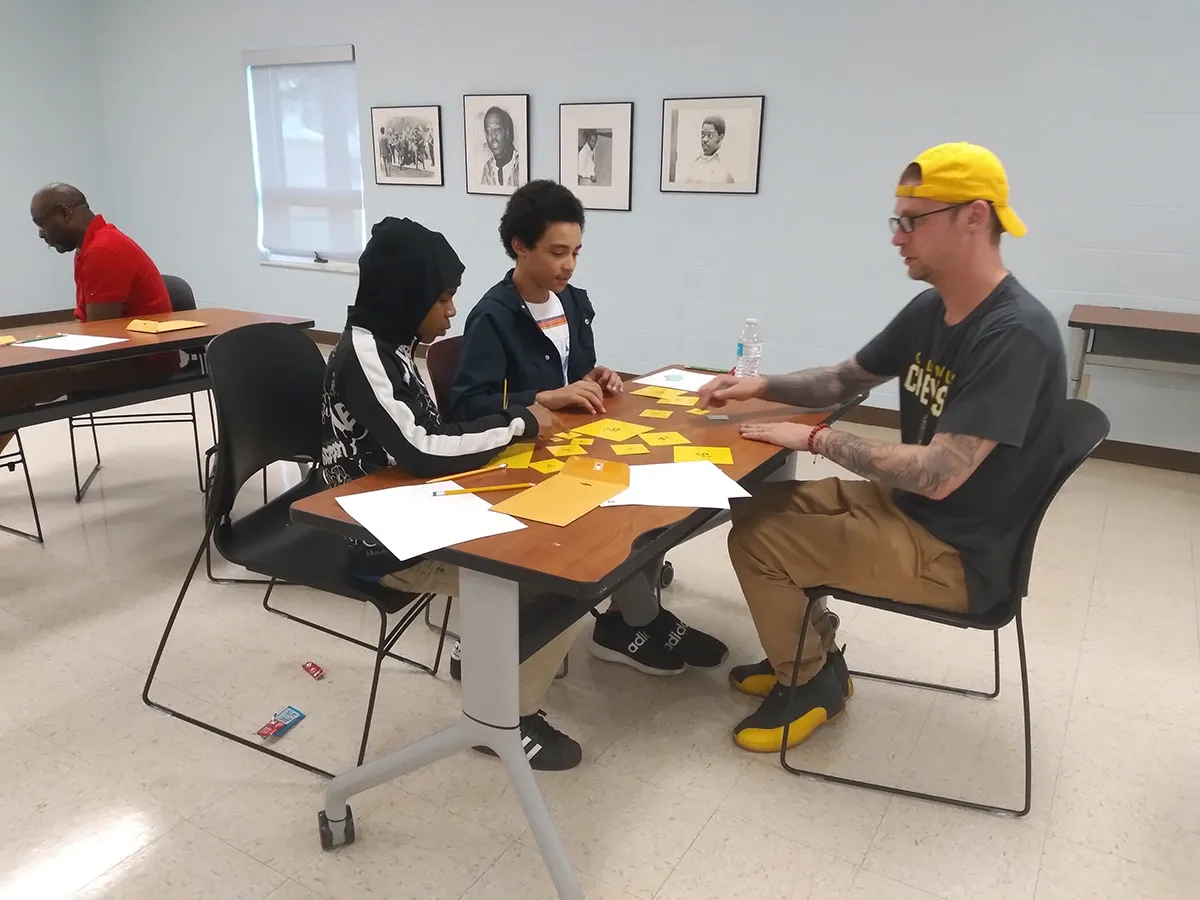 Two boys and a man playing the sum of squares game